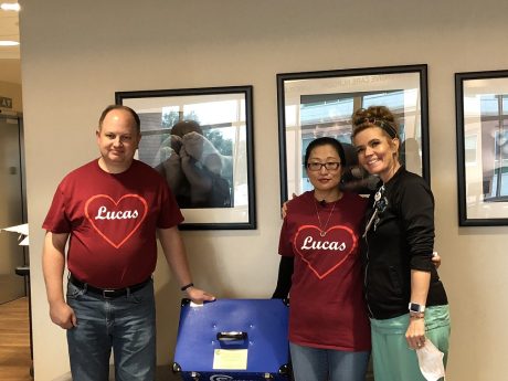 Mike and Helen Raleigh pose with Denver Health's Jaime Morelli around a CuddleCot device used by bereaved parents after the loss of a baby